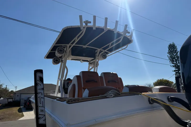 Slide: The Image of 2005 Renegade 29CC boat with canopy and seating, under clear blue sky. - 44