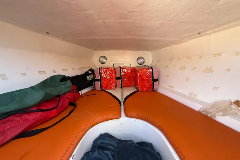Slide: The Image of Interior cabin of 2005 Renegade 29CC boat with orange seating and safety gear. - 48