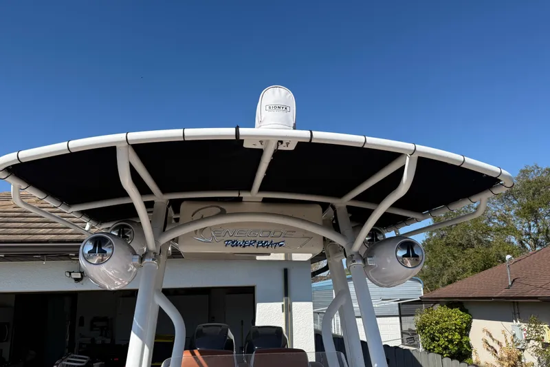 Slide: The Image of 2005 Renegade 29CC boat with canopy and speakers, parked outdoors under clear blue sky. - 55