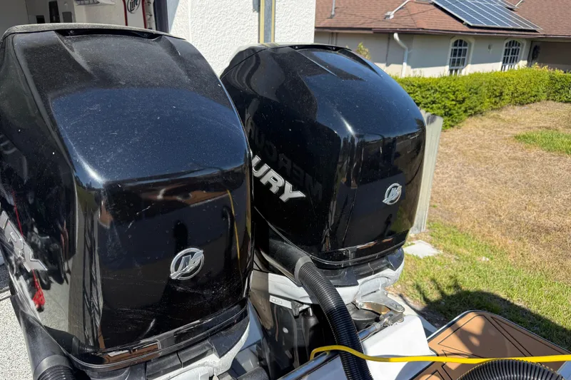Slide: The Image of Twin Mercury outboard motors on a 2005 Renegade 29CC boat, sunny day background. - 58