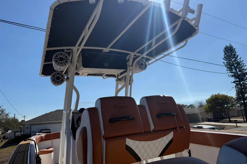 Slide: The Image of 2005 Renegade 29CC boat interior with seating and overhead speakers under a sunny sky. - 63