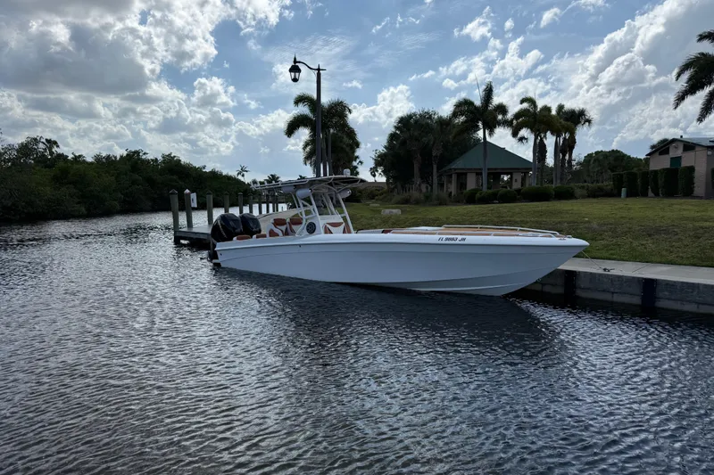Slide: The Image of 2005 Renegade 29CC boat docked by a scenic waterfront with palm trees. - 65