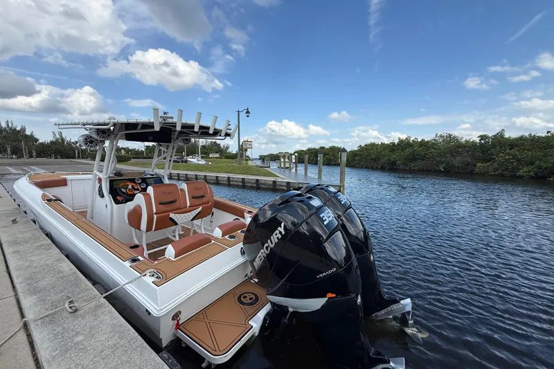 Slide: The Image of 2005 Renegade 29CC boat docked by a scenic waterway under a blue sky. - 66