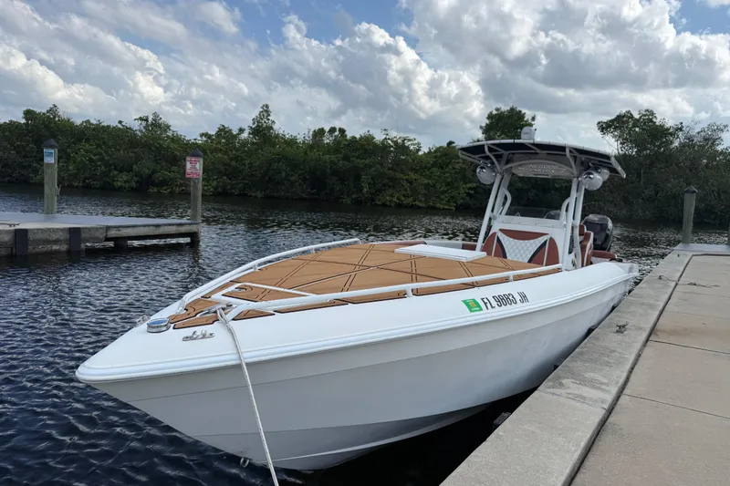 Slide: The Image of 2005 Renegade 29CC boat docked by a scenic waterfront under a cloudy sky. - 67