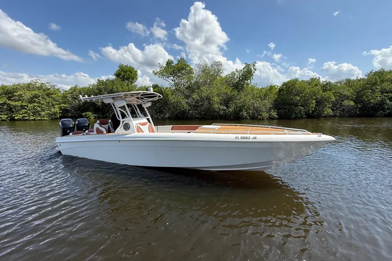 Slide: The Image of 2005 Renegade 29CC boat on calm water, surrounded by lush greenery and blue sky. - 69