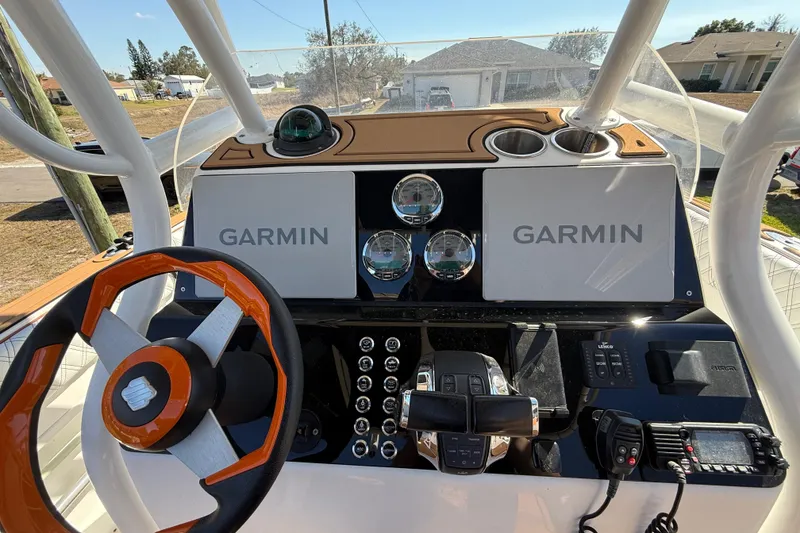 Slide: The Image of 2005 Renegade 29CC boat dashboard with Garmin displays and modern controls. - 8