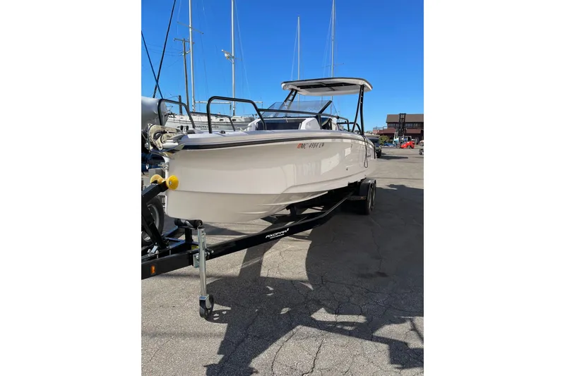 Slide: The Image of 2023 Axopar 25 Cross Top boat on trailer in marina setting. - 10
