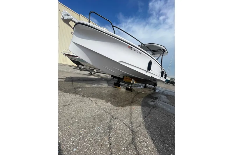 Slide: The Image of 2023 Axopar 25 Cross Top boat on dry dock, showcasing sleek design and modern features. - 13