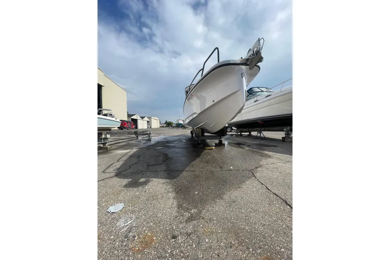 Slide: The Image of 2023 Axopar 25 Cross Top boat on dry dock under cloudy sky. - 14
