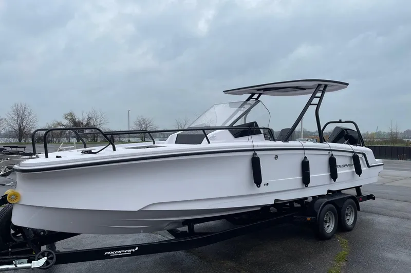 Slide: The Image of 2023 Axopar 25 Cross Top boat on trailer, overcast sky background. - 3