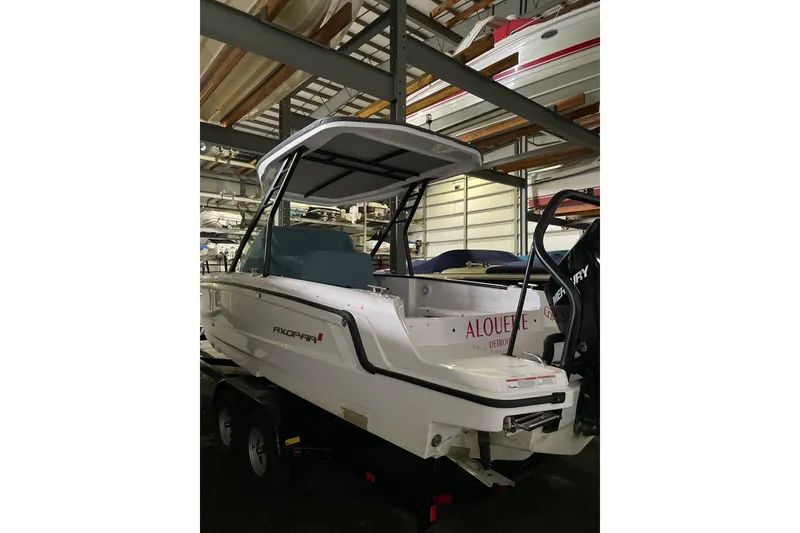 Slide: The Image of 2023 Axopar 25 Cross Top boat in storage, featuring sleek design and modern amenities. - 8