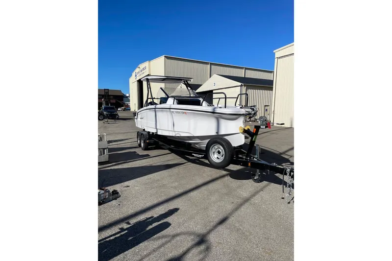 Slide: The Image of 2023 Axopar 25 Cross Top boat on trailer in industrial setting. - 9