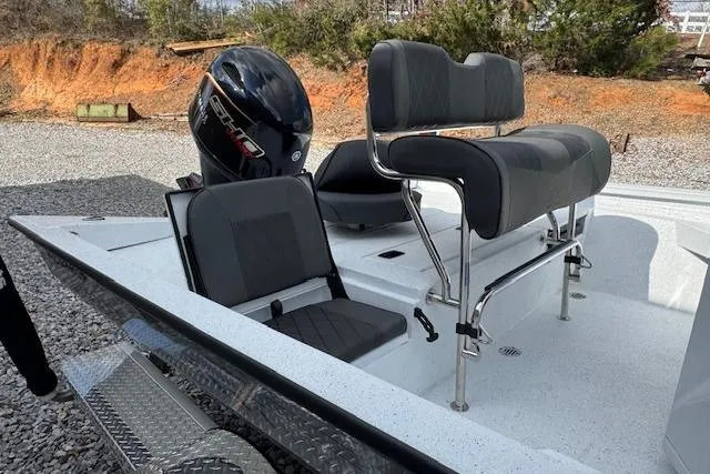 Slide: The Image of 2026 Xpress H20B Bay boat with seating and motor, parked on gravel. - 5