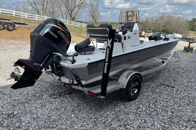 Slide: The Image of 2026 Xpress H20B Bay boat with Yamaha engine on a trailer, parked on gravel. - 7