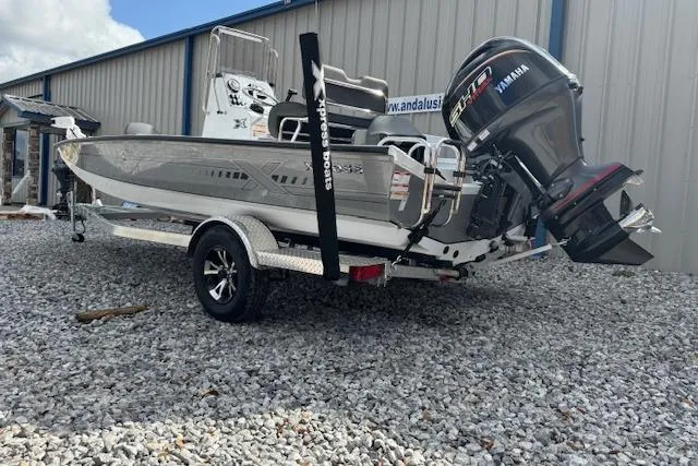 Slide: The Image of 2026 Xpress H20B Bay boat with Yamaha engine on a trailer, parked on gravel. - 9