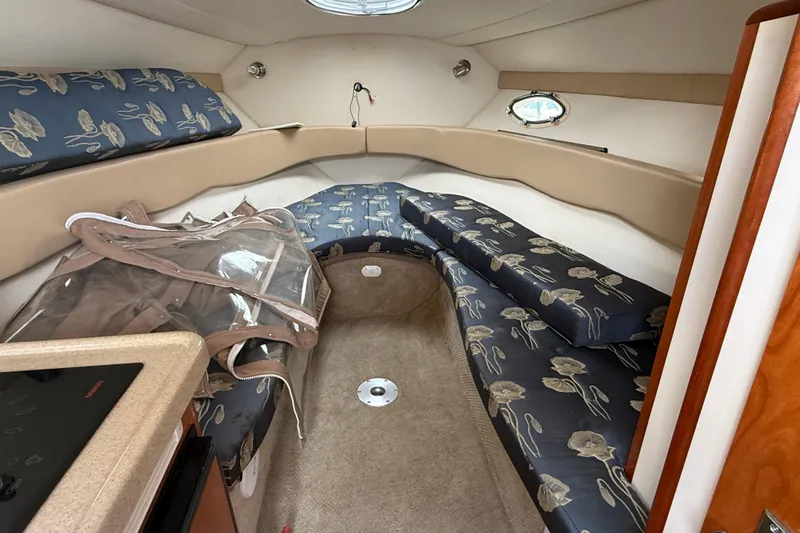 Slide: The Image of Interior of a 2004 Larson 274 boat with floral-patterned seating and compact design. - 13