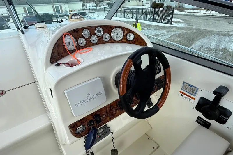 Slide: The Image of 2004 Larson 274 boat dashboard with steering wheel, gauges, and Lowrance navigation system. - 16