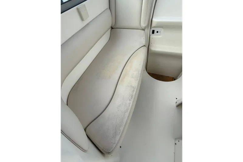 Slide: The Image of 2004 Larson 274 boat interior with white cushioned seating. - 17