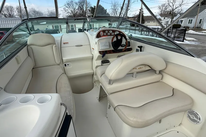 Slide: The Image of Interior of a 2004 Larson 274 boat with white seating and steering console. - 18
