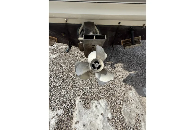 Slide: The Image of 2004 Larson 274 boat propeller on gravel surface. - 2