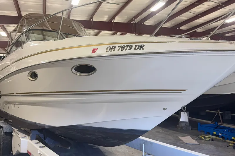 Slide: The Image of 2004 Larson 274 boat in storage, white hull with registration number OH 7079 DR. - 22