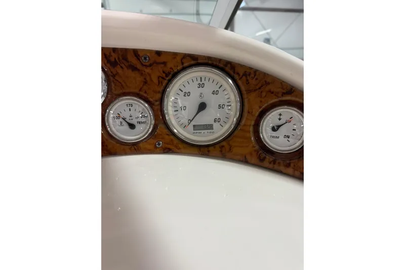 Slide: The Image of Dashboard of a 2004 Larson 274 boat with RPM, temperature, and trim gauges. - 24