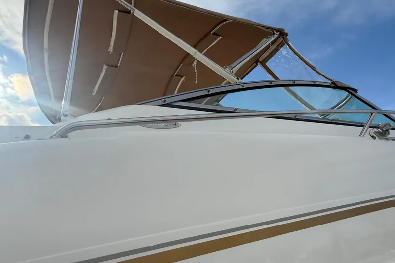 Slide: The Image of 2004 Larson 274 boat with canopy against blue sky background. - 3
