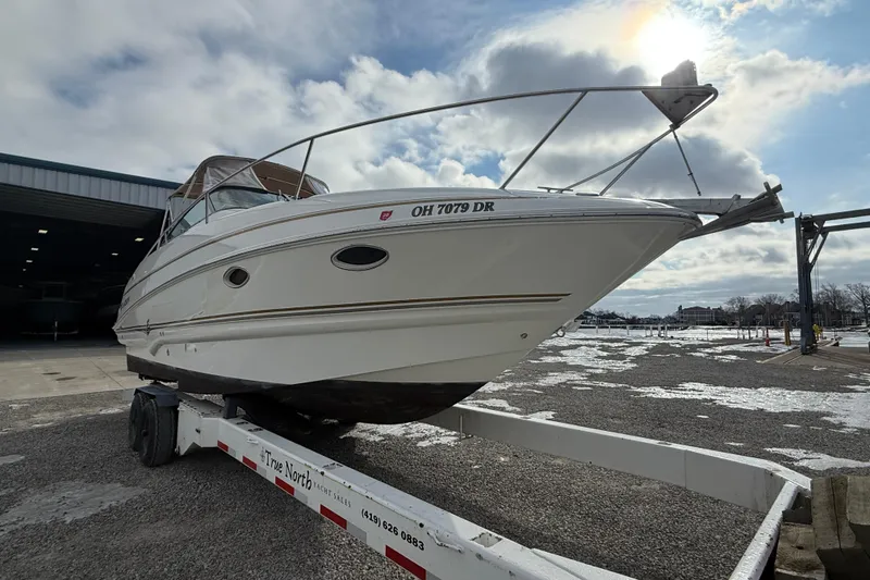 Slide: The Image of 2004 Larson 274 boat on trailer under cloudy sky at marina. - 6