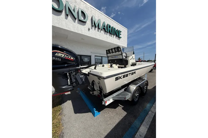 Slide: The Image of 2026 Skeeter SX221 boat on trailer outside marine dealership. - 14