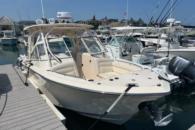 The Image of 2020 Grady-White Freedom 275 boat docked in a marina, surrounded by other vessels. - 0