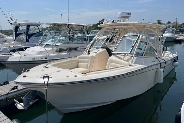 Slide: The Image of 2020 Grady-White Freedom 275 boat docked in a marina, showcasing sleek design and spacious seating. - 10