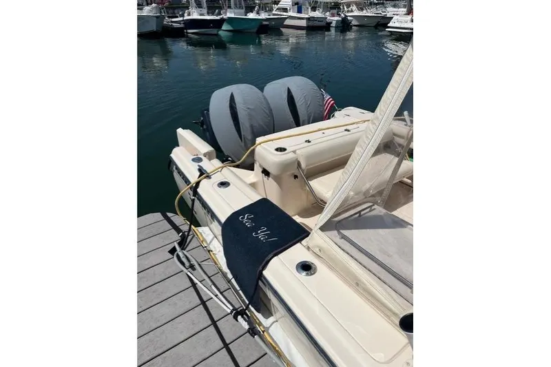 Slide: The Image of 2020 Grady-White Freedom 275 boat docked, featuring dual engines and a personalized mat. - 2