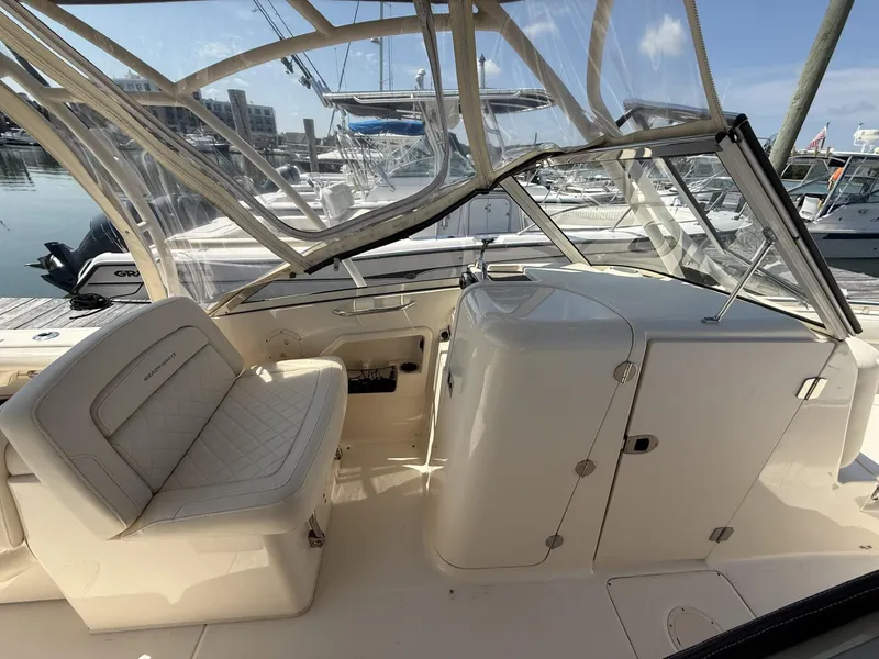 Slide: The Image of 2017 Grady-White Freedom 275 boat interior with seating and clear canopy at marina. - 4