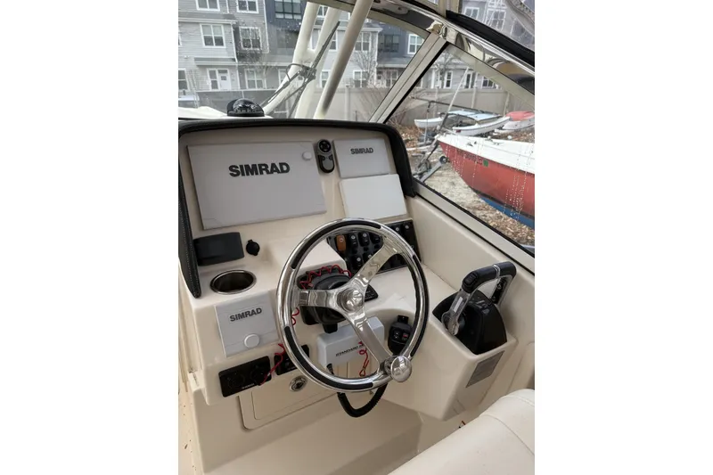 Slide: The Image of 2020 Grady-White Freedom 275 boat helm with Simrad electronics and steering wheel. - 7