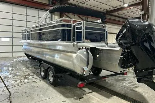Slide: The Image of 2026 Sun Tracker SportFish 22 XP3 pontoon boat in a warehouse setting. - 4