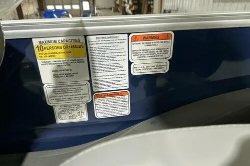 Slide: The Image of 2026 Sun Tracker SportFish 22 XP3 capacity and warning labels on boat interior. - 8