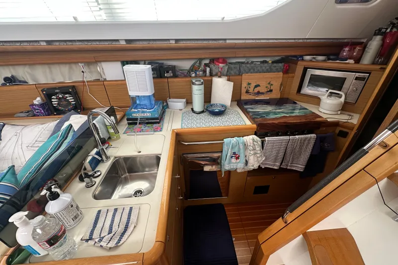 Slide: The Image of Interior of 2008 Jeanneau Sun Odyssey 45 DS yacht kitchen with sink, microwave, and wooden cabinetry. - 13