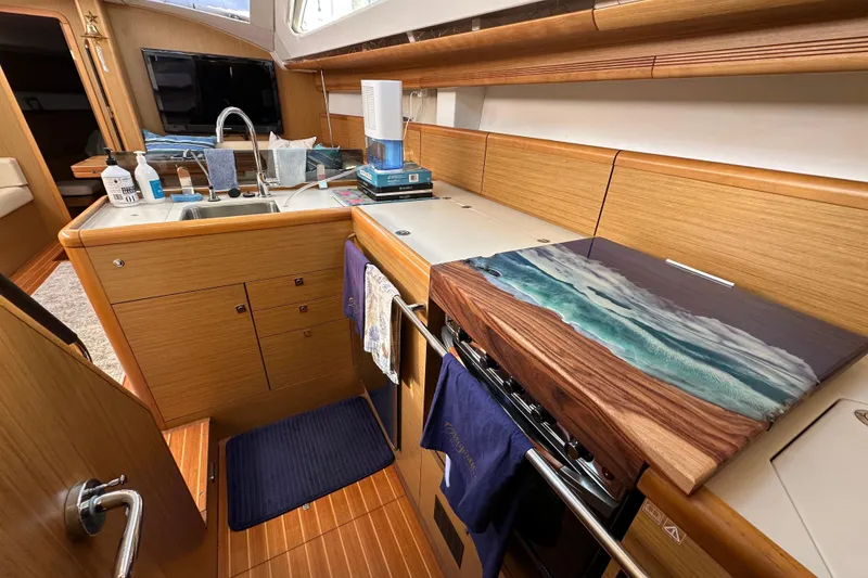 Slide: The Image of Luxurious 2008 Jeanneau Sun Odyssey 45 DS yacht kitchen with modern amenities and elegant wood finish. - 35