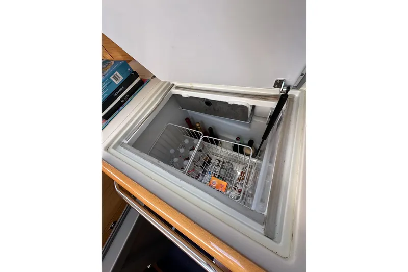 Slide: The Image of Open fridge on 2008 Jeanneau Sun Odyssey 45 DS yacht, stocked with drinks and snacks. - 37