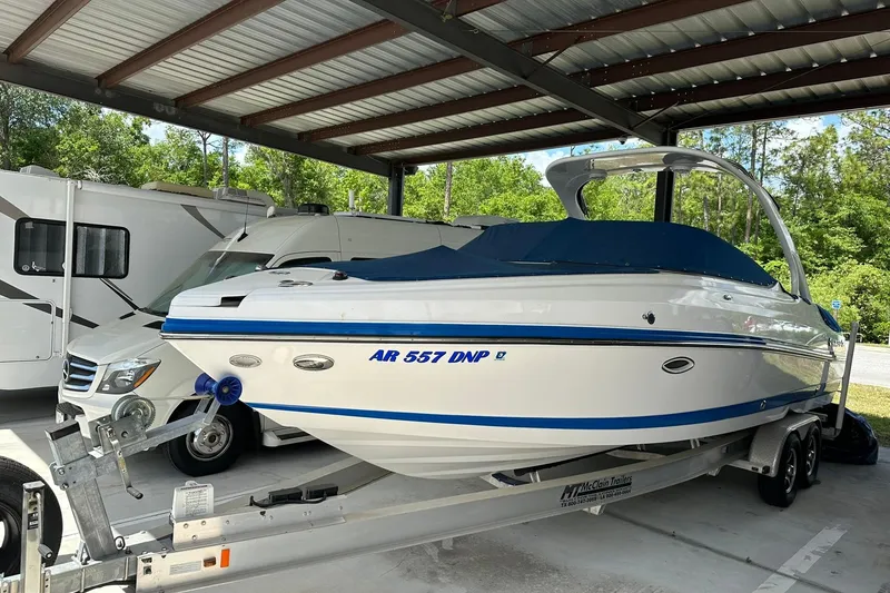 The Image of 2013 Rinker 276 Captiva Bowrider on trailer under shelter, next to RV. - 0