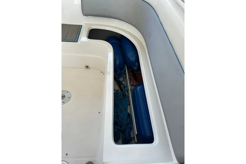 Slide: The Image of Storage compartment in 2013 Rinker 276 Captiva Bowrider with blue fenders and rope. - 11