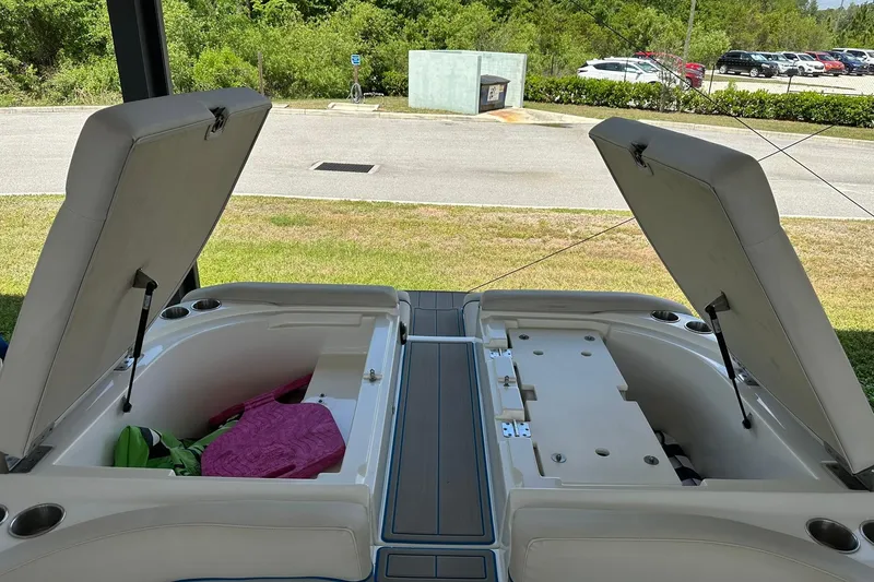Slide: The Image of 2013 Rinker 276 Captiva Bowrider storage compartments open, showcasing interior space. - 13