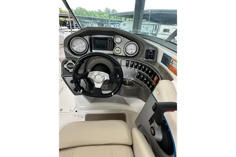 Slide: The Image of 2013 Rinker 276 Captiva Bowrider dashboard with steering wheel and control panel. - 2