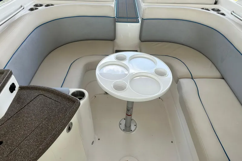 Slide: The Image of 2013 Rinker 276 Captiva Bowrider interior with round table and cushioned seating. - 20
