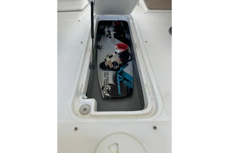 Slide: The Image of 2013 Rinker 276 Captiva Bowrider storage compartment with wakeboard inside. - 25