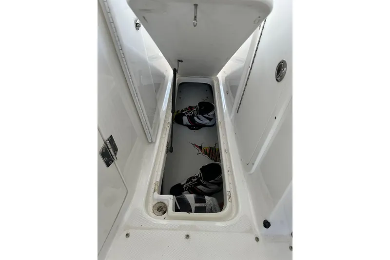 Slide: The Image of 2013 Rinker 276 Captiva Bowrider storage compartment with wakeboard equipment. - 26