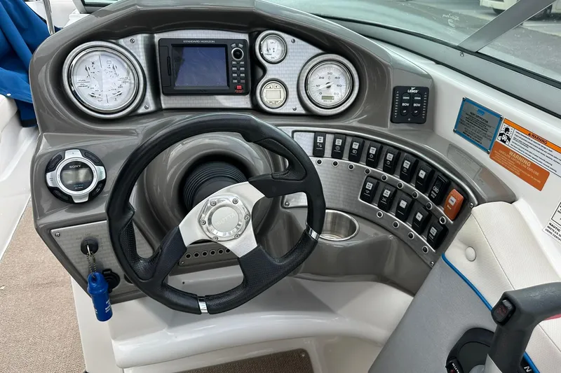 Slide: The Image of 2013 Rinker 276 Captiva Bowrider dashboard with steering wheel and control panel. - 31