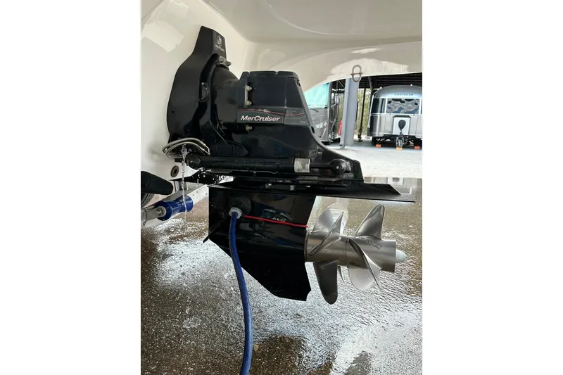 Slide: The Image of 2013 Rinker 276 Captiva Bowrider with MerCruiser outdrive, wet surface, and visible propeller. - 39