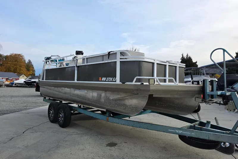 Slide: The Image of 2001 J C Manufacturing TRITOON 226 I/O pontoon boat on trailer in outdoor setting. - 0