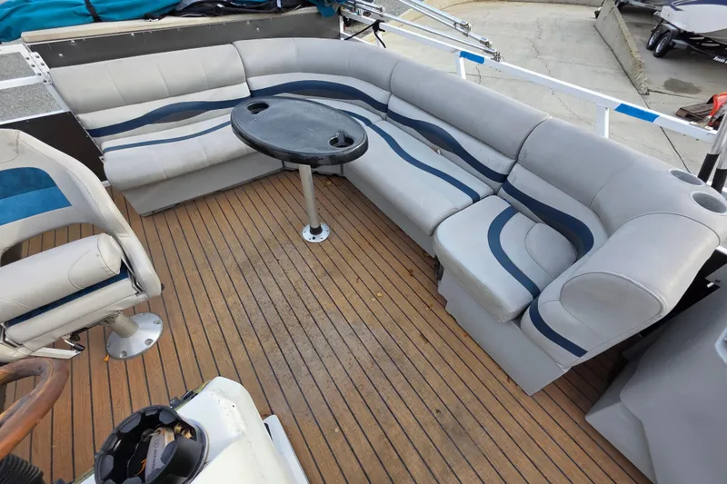 Slide: The Image of 2001 J C Manufacturing TRITOON 226 I/O boat interior with cushioned seating and table. - 6